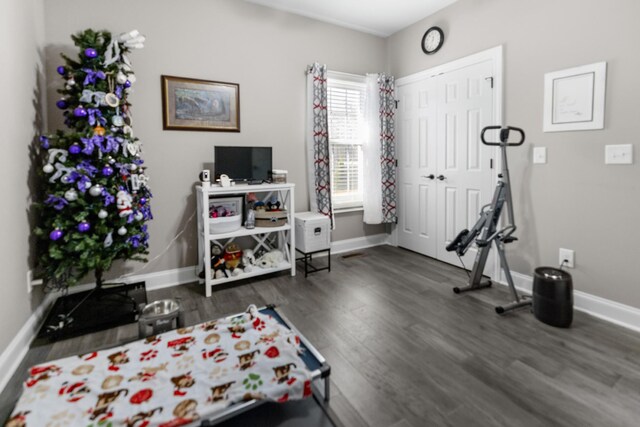 exercise area with baseboards and dark wood-style floors