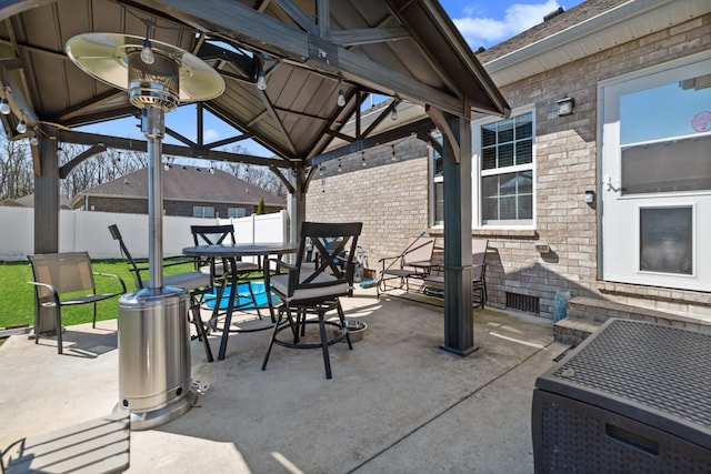view of patio featuring a gazebo, fence, and outdoor dining space