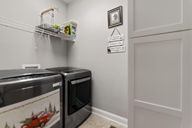 laundry room featuring baseboards, light tile patterned floors, laundry area, and washer and dryer