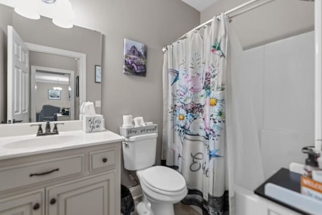 full bathroom with toilet, vanity, and shower / bath combo