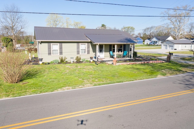 view of front facade with covered porch, metal roof, and a front yard