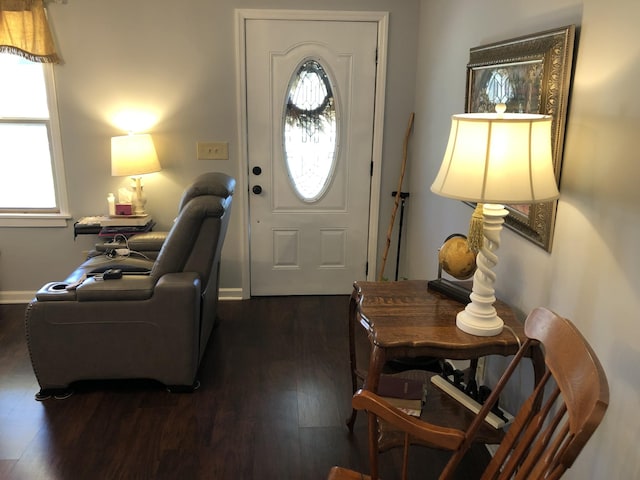 foyer with dark wood-style flooring and baseboards
