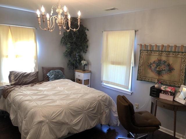 bedroom with multiple windows, visible vents, and a notable chandelier