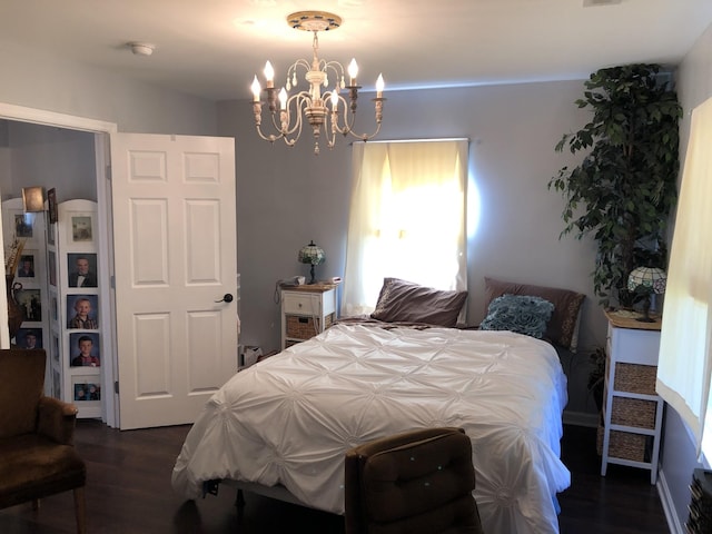 bedroom with dark wood-style flooring and a notable chandelier
