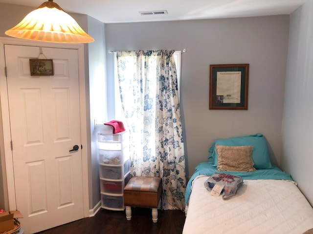 bedroom with visible vents, multiple windows, and dark wood finished floors