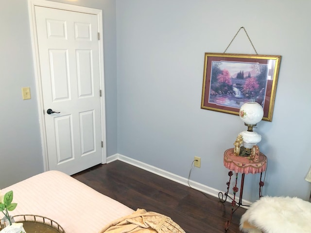 bedroom with dark wood-style flooring and baseboards