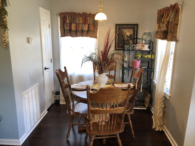 dining area with visible vents, baseboards, and wood finished floors