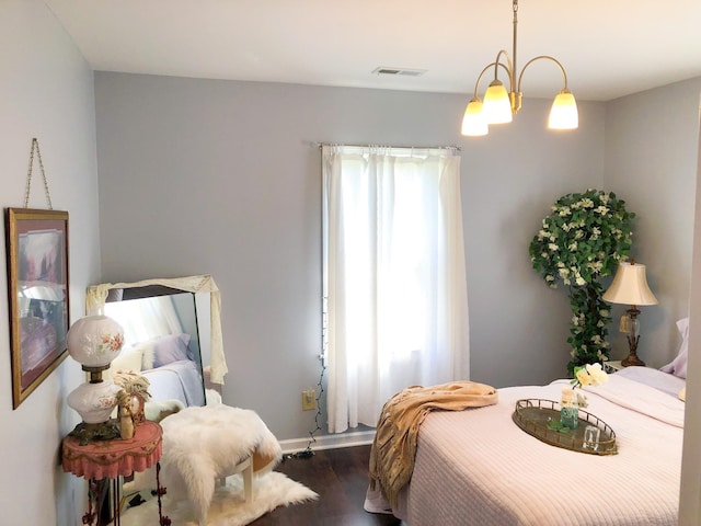 bedroom featuring an inviting chandelier, dark wood-style flooring, baseboards, and visible vents