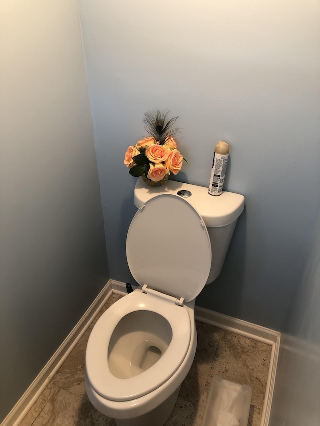 bathroom featuring toilet and baseboards