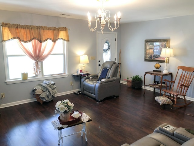 living room featuring baseboards, a wealth of natural light, wood finished floors, and an inviting chandelier