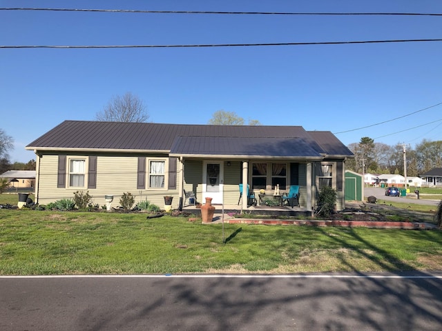view of front facade featuring a front lawn, metal roof, and a porch