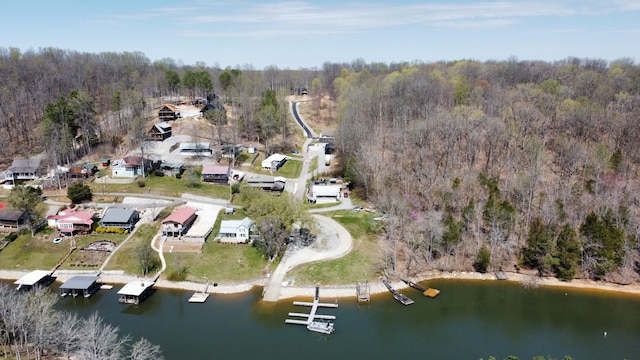 birds eye view of property featuring a forest view and a water view
