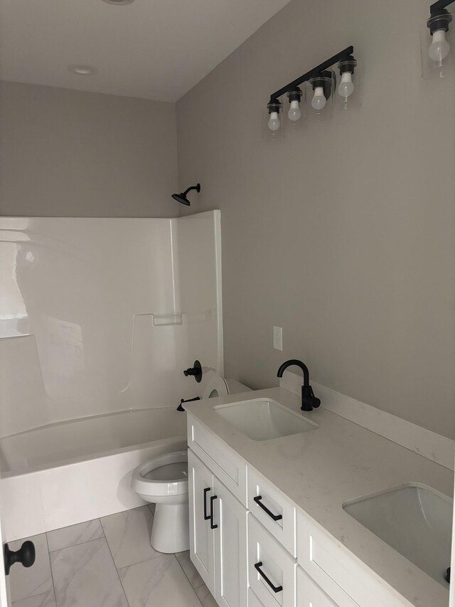 bathroom featuring toilet, marble finish floor, a sink, and shower / washtub combination