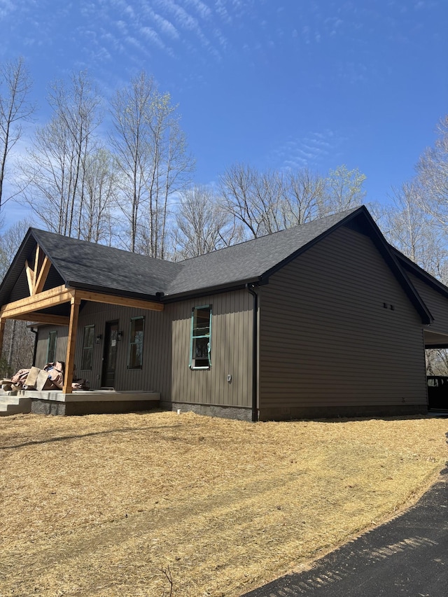 exterior space featuring a porch and roof with shingles