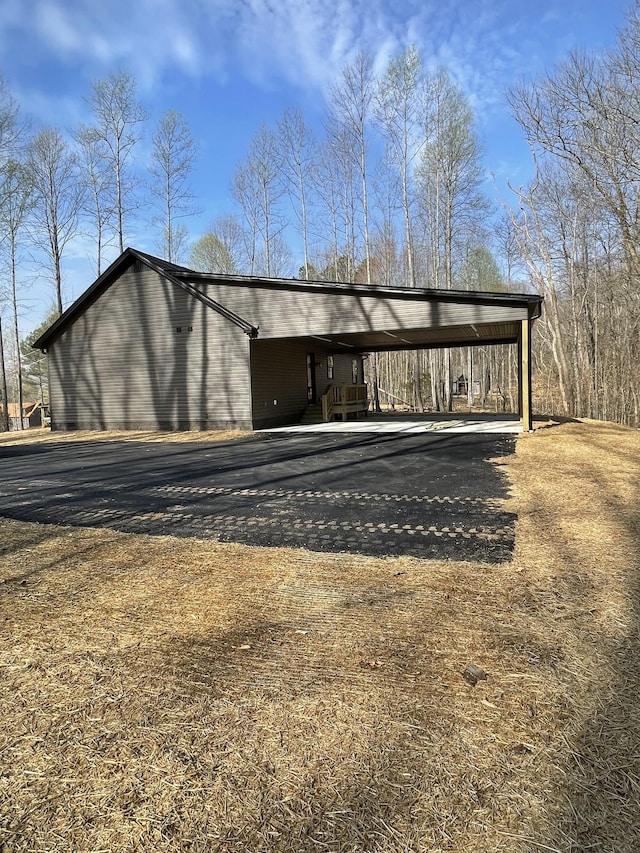 view of outdoor structure with a carport and aphalt driveway