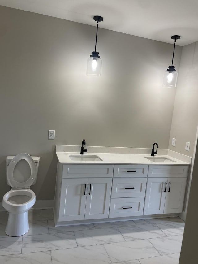 bathroom with a sink, toilet, and marble finish floor