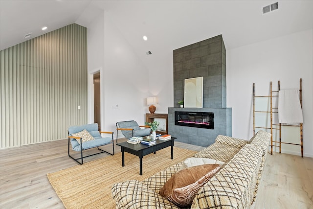 2510 Vaulx Ln, Nashville, TN 37204 - living room with baseboards, visible vents, high vaulted ceiling, a tile fireplace, and wood finished floors