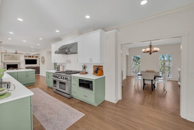 1237 Temple Ridge Dr, Nashville, TN 37221 - kitchen featuring range with two ovens, wall chimney range hood, green cabinetry, a notable chandelier, and black microwave