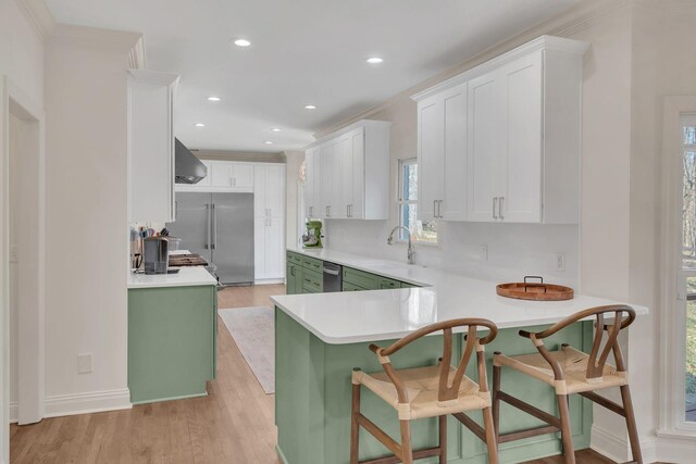 1237 Temple Ridge Dr, Nashville, TN 37221 - kitchen featuring light countertops, light wood-type flooring, exhaust hood, a sink, and appliances with stainless steel finishes