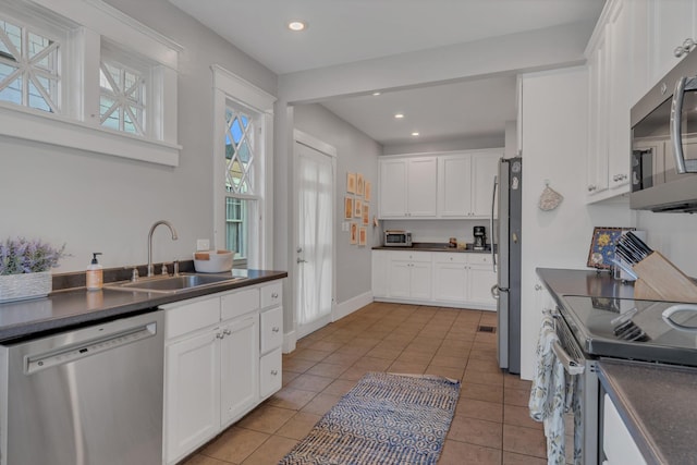3814 Central Ave, Nashville, TN 37205 - kitchen with dark countertops, appliances with stainless steel finishes, white cabinetry, a sink, and light tile patterned floors
