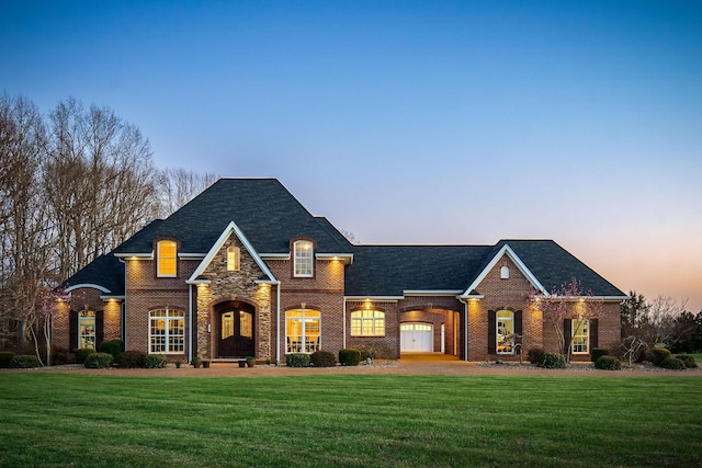 french provincial home featuring brick siding and a front lawn