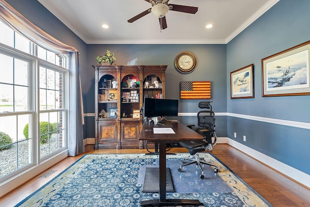 home office with wood finished floors, baseboards, visible vents, ceiling fan, and ornamental molding