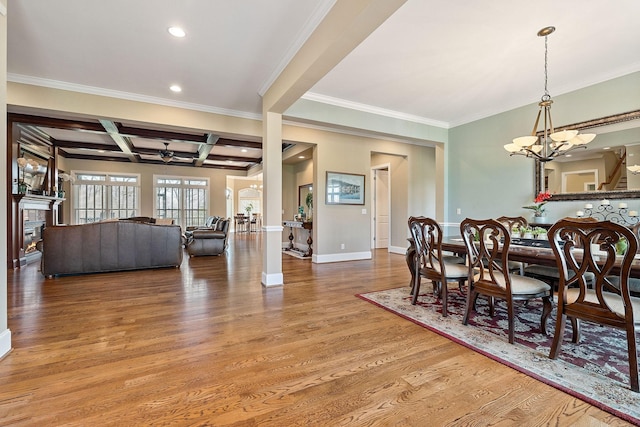 dining area with coffered ceiling, beam ceiling, a warm lit fireplace, wood finished floors, and baseboards
