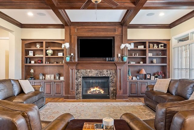 living area featuring coffered ceiling, a high end fireplace, wood finished floors, and beam ceiling
