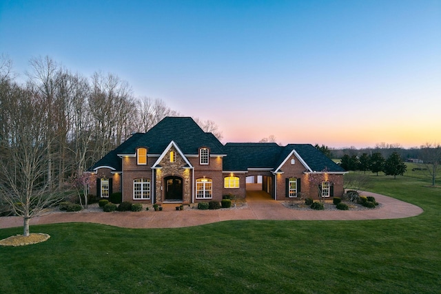 view of front of home featuring brick siding and a yard