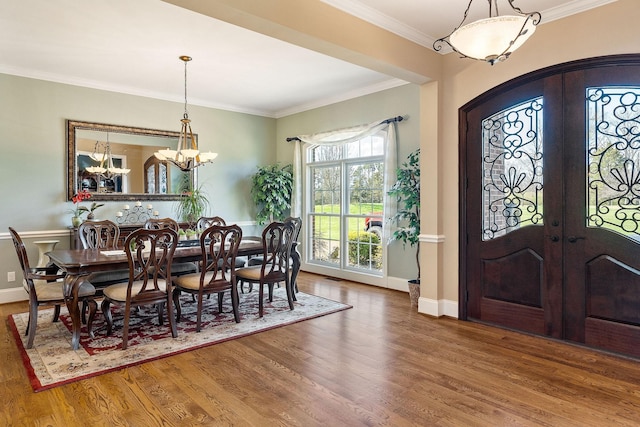 dining area featuring baseboards, wood finished floors, french doors, and crown molding