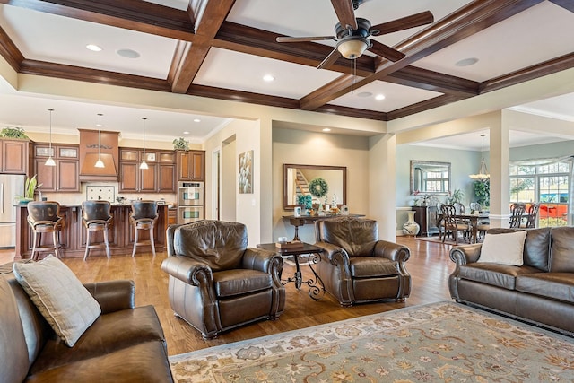 living area featuring light wood-style flooring, coffered ceiling, a ceiling fan, and beam ceiling