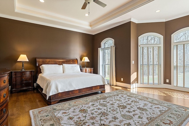 bedroom with ornamental molding, wood finished floors, ceiling fan, recessed lighting, and a raised ceiling