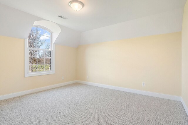 additional living space with baseboards, carpet flooring, visible vents, and vaulted ceiling