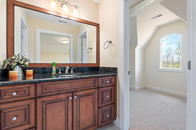 bathroom featuring baseboards, lofted ceiling, visible vents, and vanity