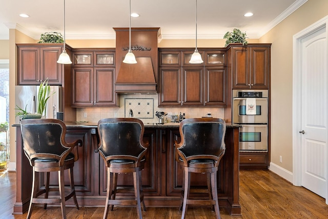 kitchen featuring dark wood-style floors, dark countertops, custom range hood, and appliances with stainless steel finishes