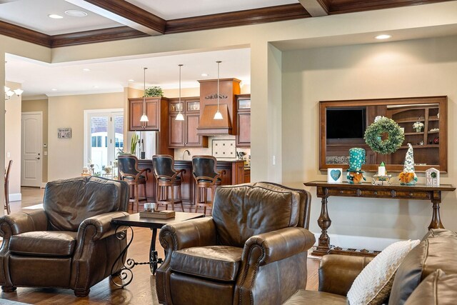 living area featuring beamed ceiling, wood finished floors, ornamental molding, and recessed lighting