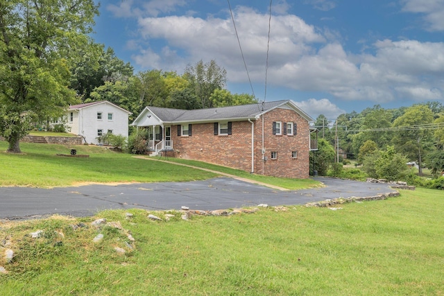 single story home featuring brick siding and a front lawn