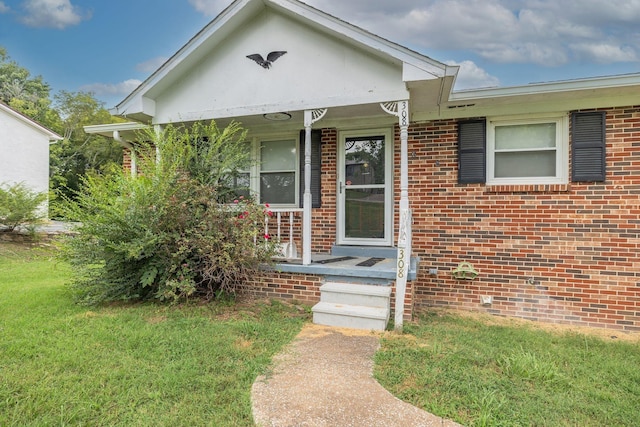 view of front facade with covered porch, brick siding, and a front lawn