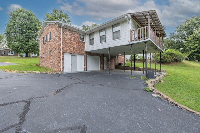 view of front of home with driveway, brick siding, a front lawn, and a carport