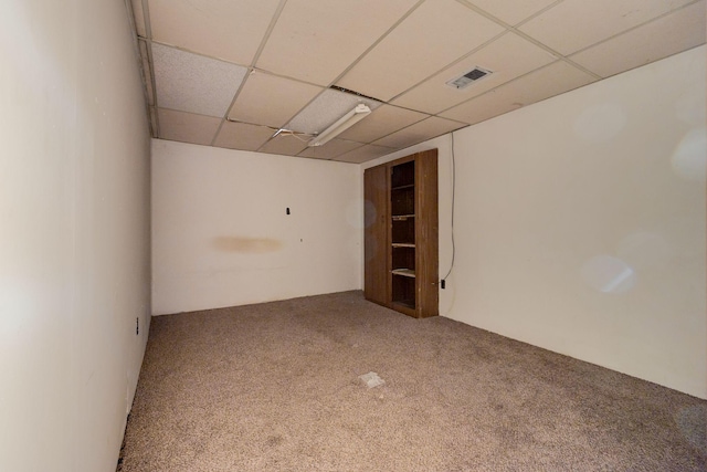 carpeted spare room with visible vents and a paneled ceiling