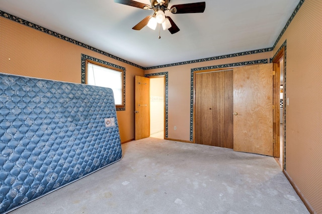unfurnished bedroom with a closet, carpet flooring, and a ceiling fan