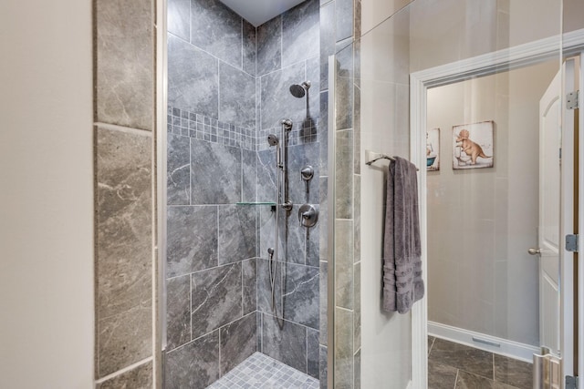 bathroom featuring baseboards and tiled shower