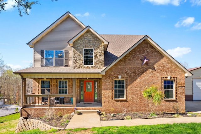 traditional-style home featuring covered porch, a shingled roof, and brick siding