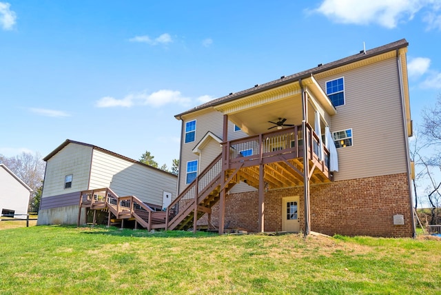 rear view of property featuring a deck, ceiling fan, stairway, and a yard