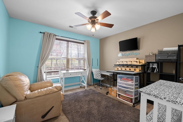 carpeted home office featuring baseboards, ceiling fan, and visible vents