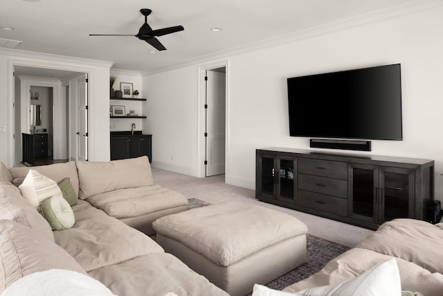 carpeted living area featuring baseboards, ceiling fan, and crown molding