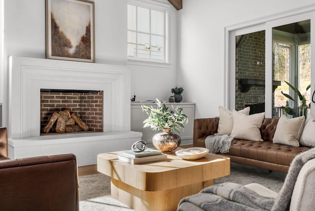 living area featuring a fireplace with raised hearth and wood finished floors
