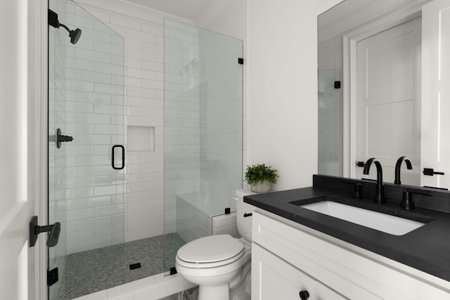 bathroom with toilet, a stall shower, and vanity