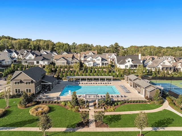 pool with a lawn, fence, and a residential view