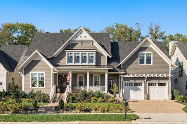 craftsman-style house featuring driveway, a garage, a standing seam roof, and a porch